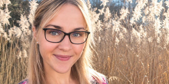 Foto von Dr. Larissa Pliska vor einer Schilflandschaft