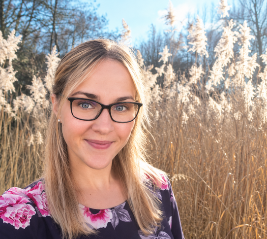 Foto von Dr. Larissa Pliska vor einer Schilflandschaft