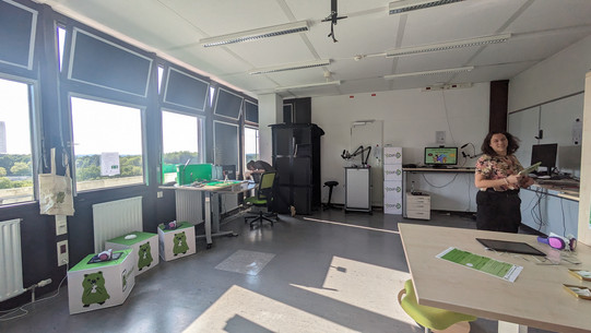 Blick ins Labor Foto des Digitalen Medienlabors von innen. Es sind Jana Jungjohann und Luisa Jost zu sehen, wie sie die Laptops und Tables anstellen.