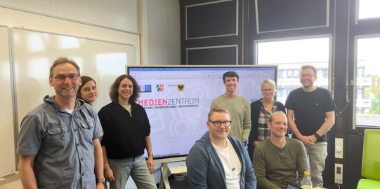 Gruppenfoto der Teilnehmenden des Austauschs: Claudia Wierz (Leitung des Medienzentrums), Burkhard Pesch (Medienberater der Zentren für schulpraktische Lehrerausbildung), Daniel Baldauf (Medienberater der Bezirksregierung Arnsberg mit dem Schwerpunkt Grundschule), Anna-Louisa Jesudason (Medienberaterin der Bezirksregierung Arnsberg mit Förderschulexpertise), Marc Litzmanski (Medienberater der Bezirksregierung Arnsberg für Gesamtschulen und Grundschulen), Mirco Urbaniak (Medienberater der Bezirksregierung Arnsberg für Gymnasien) und Sven Stumpe (Medienberater der Bezirksregierung Arnsberg für Grundschulen mit dem Schwerpunkt Programmieren) sowie Gastgeberin Jun.-Prof. Dr. Jana Jungjohann.