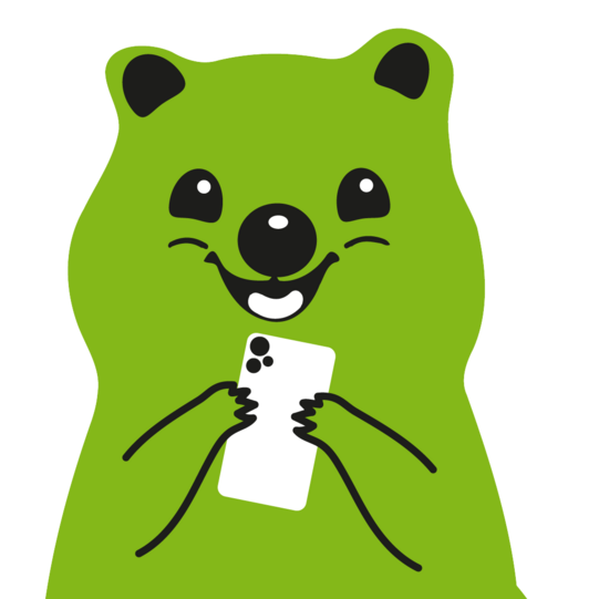 Es ist ein Foto von dem Maskottchen Fibsi. Fibsi hält ein weißes Smartphone in den Händen.