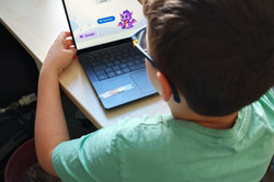 Junge probiert am Laptop eine Leseapp aus