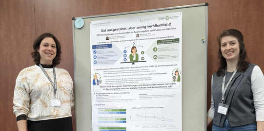 Foto von Maxine Klinck und Jana Jungjohann (beide stehend) vor ihrem wissenschaftlichen Poster