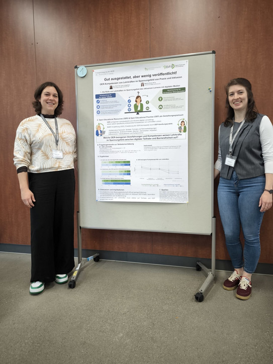 Foto von Maxine Klinck und Jana Jungjohann (beide stehend) vor ihrem wissenschaftlichen Poster