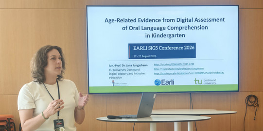 Foto von Jun-.Prof. Dr. Jana Jungjohann in sitzender Position vor der ersten Vortragsfolie mit dem Vortragstitel Age-Related Evidence from Digital Assessment of Oral Language Comprehension in Kindergarten auf der ERALI SIG 5 2026 in Jyväskylä